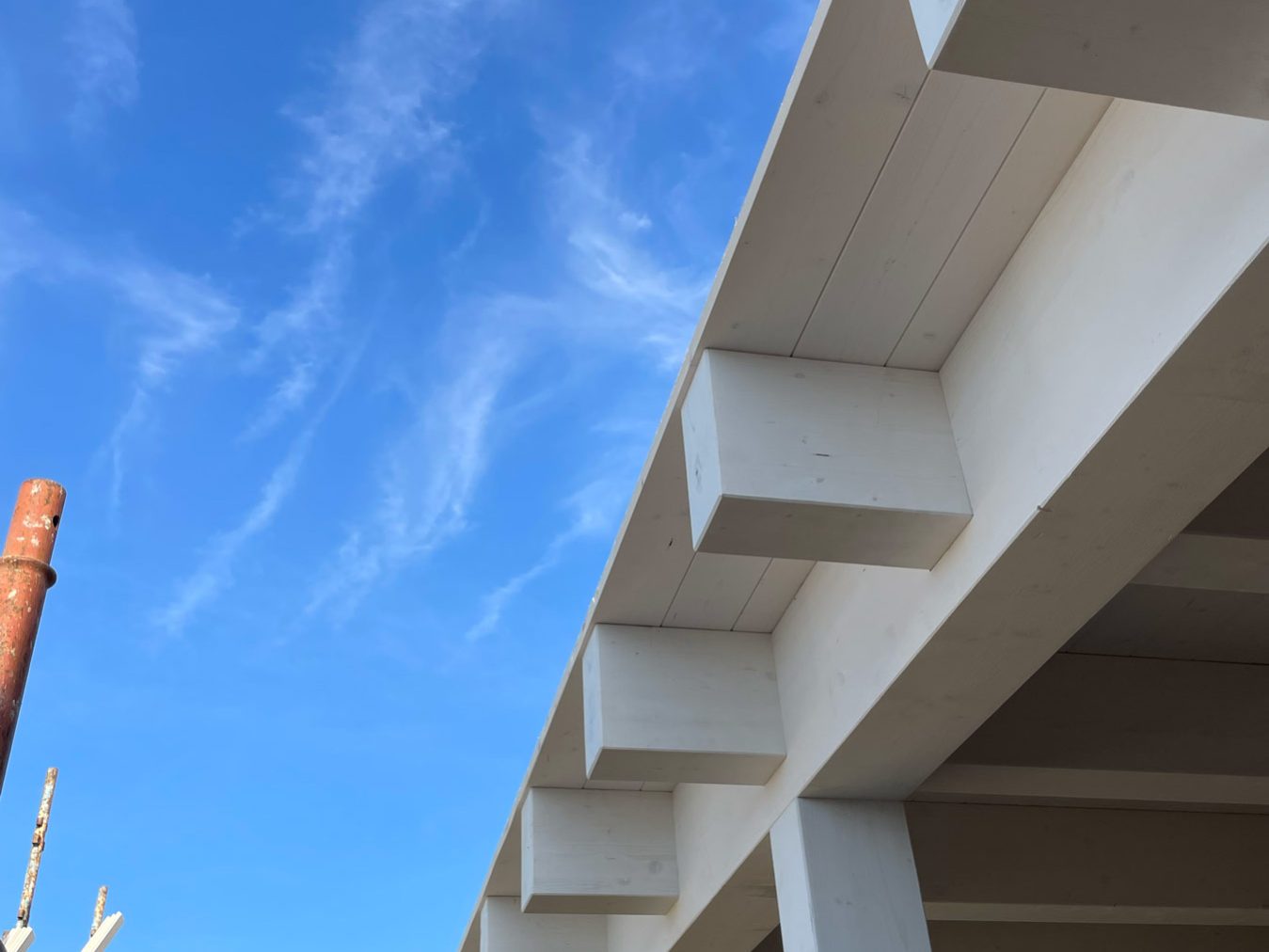 Cantiere di una casa a struttura in legno con travi sbiancate sul soffitto